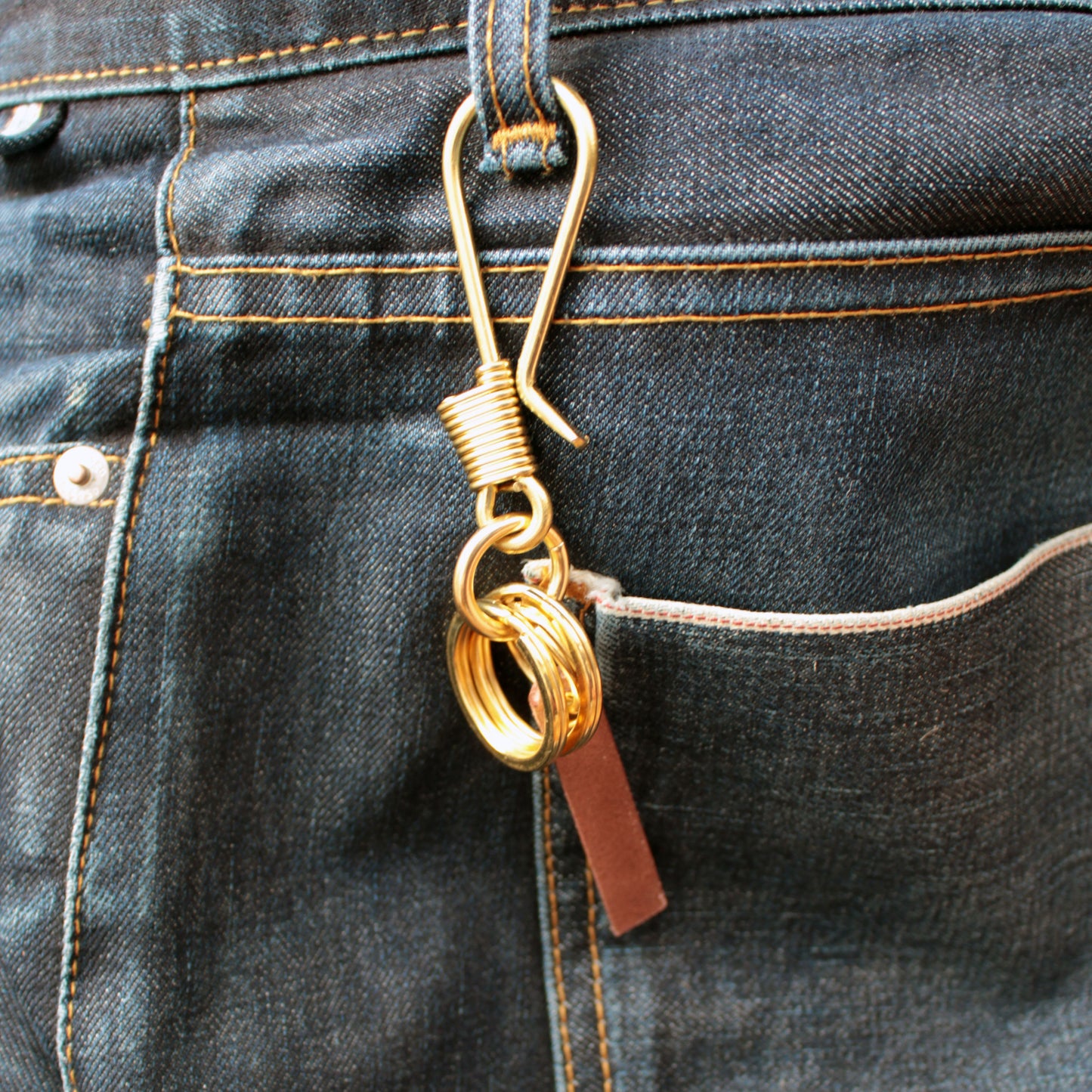 Solid brass key holder on denim belt loop