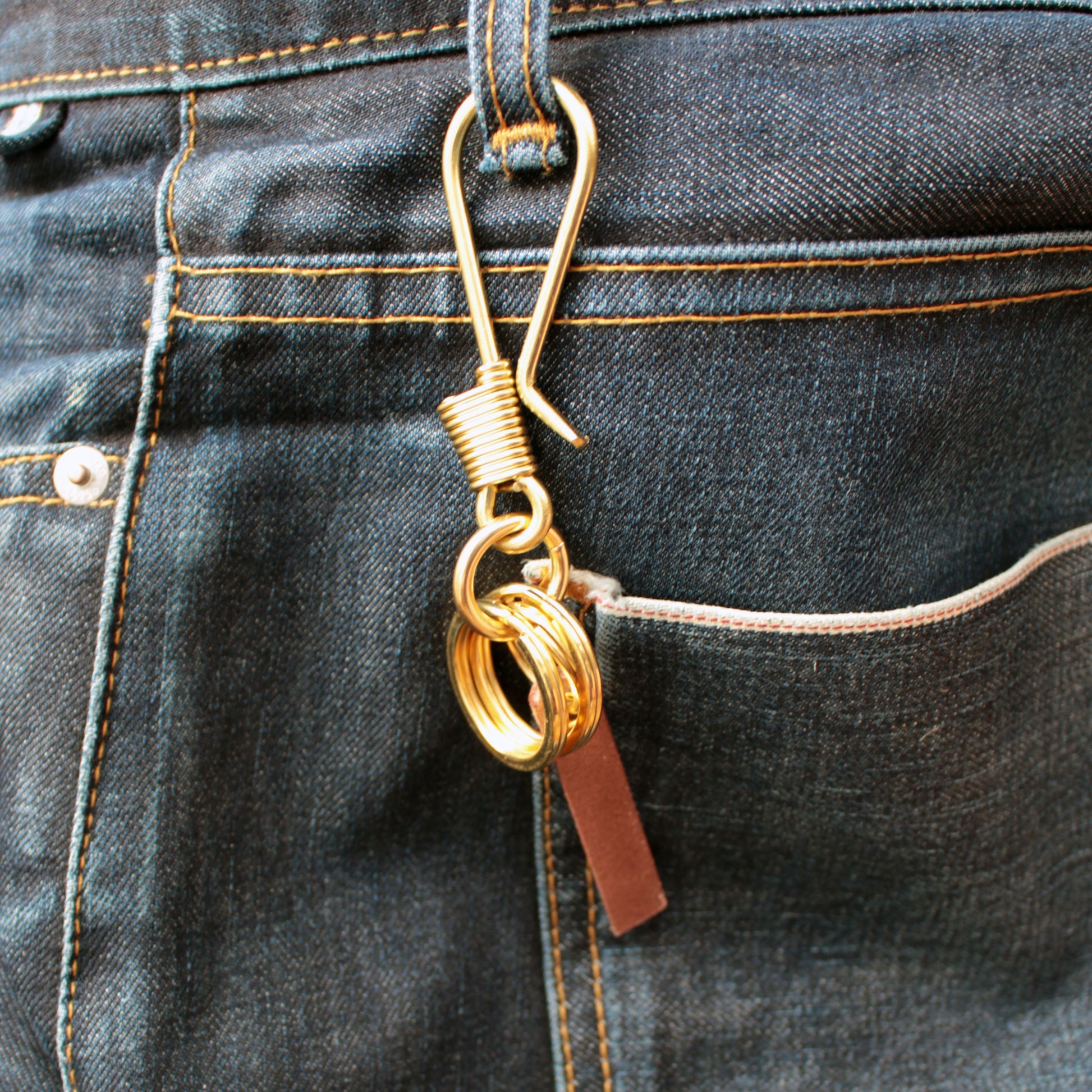 Solid brass key holder on denim belt loop